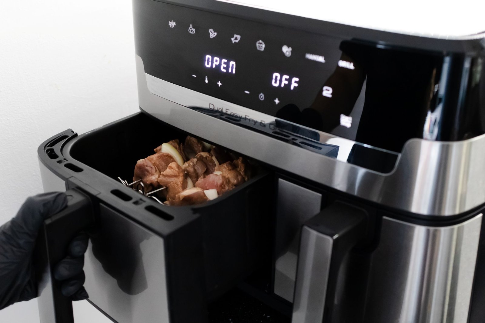 Medidor de consumo eléctrico junto a una Air Fryer FOXBOX Genus Aeris en una cocina moderna.